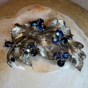Lisner vintage silver-tone floral brooch with blue aurora borealis rhinestones.